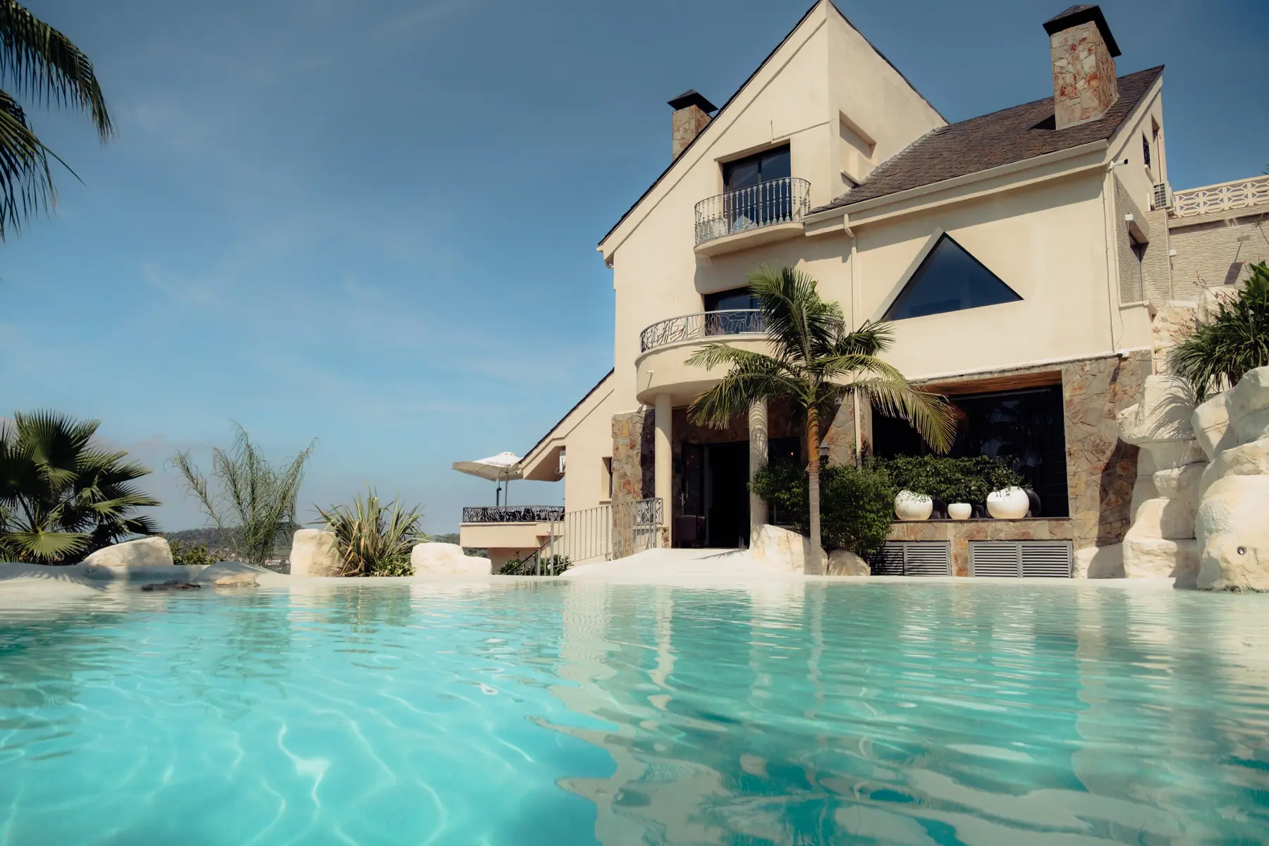 Piscina de Petit Mirador amb la casa i el paisatge al fons